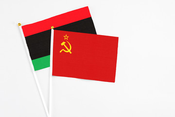 Soviet Union and Libya stick flags on white background. High quality fabric, miniature national flag. Peaceful global concept.White floor for copy space.