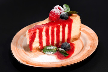 Delicious strawberry cheesecake slice and fresh berries on table close up