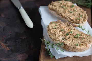 Fresh homemade chicken liver pate. Chicken liver pate on bread and in jar on a dark background