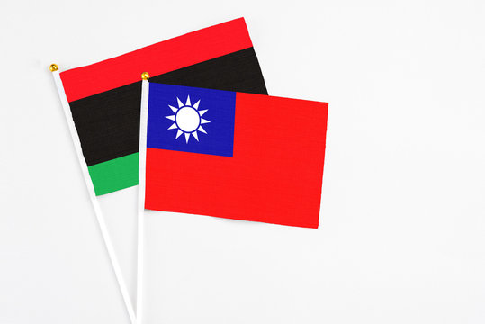 Taiwan and Libya stick flags on white background. High quality fabric, miniature national flag. Peaceful global concept.White floor for copy space.