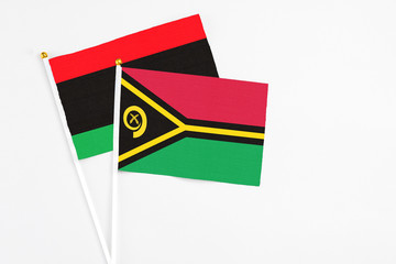 Vanuatu and Libya stick flags on white background. High quality fabric, miniature national flag. Peaceful global concept.White floor for copy space.