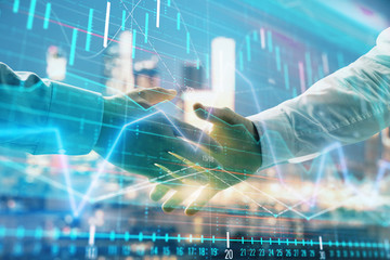 Double exposure of financial chart on cityscape background with two businessmen handshake. Concept of financial analysis and investment opportunities