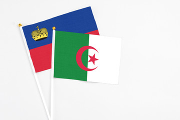 Algeria and Liechtenstein stick flags on white background. High quality fabric, miniature national flag. Peaceful global concept.White floor for copy space.
