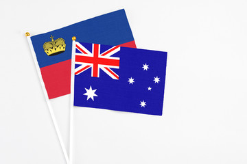 Fototapeta premium Australia and Liechtenstein stick flags on white background. High quality fabric, miniature national flag. Peaceful global concept.White floor for copy space.