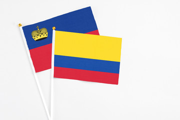 Colombia and Liechtenstein stick flags on white background. High quality fabric, miniature national flag. Peaceful global concept.White floor for copy space.