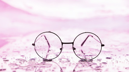 Tools for vision correction. Glasses and lenses with diopters on the background of splashes and...