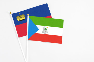Equatorial Guinea and Liechtenstein stick flags on white background. High quality fabric, miniature national flag. Peaceful global concept.White floor for copy space.