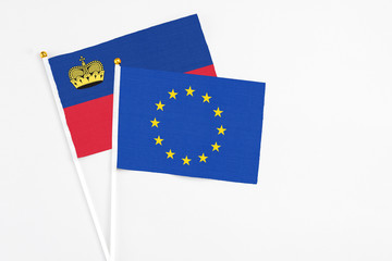 European Union and Liechtenstein stick flags on white background. High quality fabric, miniature national flag. Peaceful global concept.White floor for copy space.