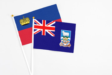 Falkland Islands and Liechtenstein stick flags on white background. High quality fabric, miniature national flag. Peaceful global concept.White floor for copy space.