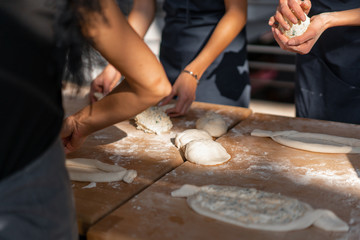 Culinary master class. Closeup of people hands preparing khachapuri. Traditional georgian cheese...