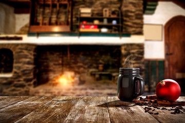 Christmas mugs with a hot drink. Steam smoke and Christmas decoration. Blurry background of a rustic fireplace with flame. American rifles on a stand. Place for your christmas gifts.Dark mood shadows.