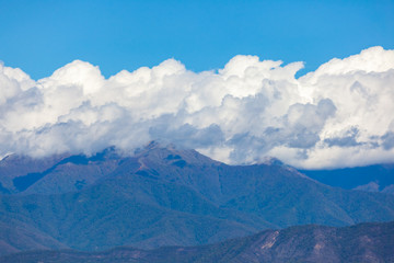 View of the peaks of the mountains in Kakheti and white clouds on blue sky.