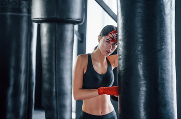 Young woman in sportive wear is in the gym having exercise day. Conception of boxing