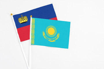 Kazakhstan and Liechtenstein stick flags on white background. High quality fabric, miniature national flag. Peaceful global concept.White floor for copy space.