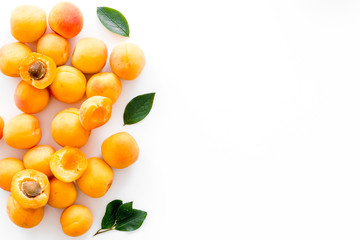 Fruit frame. Apricots and leaves on white background top view copy space