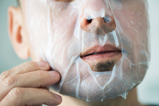 Man Applying A Facial Mask To Himself.