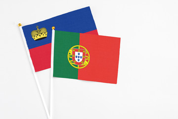 Portugal and Liechtenstein stick flags on white background. High quality fabric, miniature national flag. Peaceful global concept.White floor for copy space.