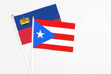 Puerto Rico and Liechtenstein stick flags on white background. High quality fabric, miniature national flag. Peaceful global concept.White floor for copy space.