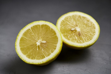 Cut lemon on a grey background. Healthy fruits.