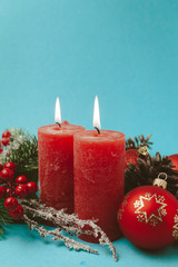 Beautiful New Year and Christmas decor. Red burning candles, balls, Christmas tree and cones.