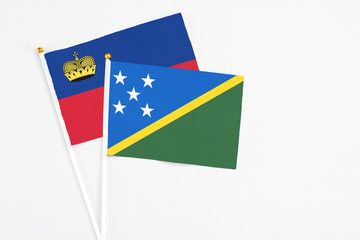 Solomon Islands and Liechtenstein stick flags on white background. High quality fabric, miniature...