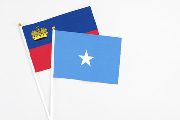 Somalia and Liechtenstein stick flags on white background. High quality fabric, miniature national flag. Peaceful global concept.White floor for copy space.