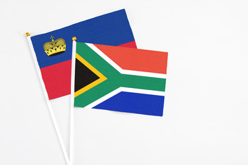 South Africa and Liechtenstein stick flags on white background. High quality fabric, miniature national flag. Peaceful global concept.White floor for copy space.