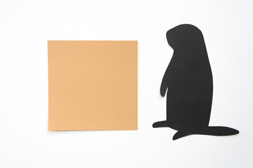 Groundhog day. Groundhog silhouette cut from black paper and brown blank sticker writing paper on white background. Space for text