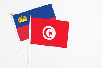 Tunisia and Liechtenstein stick flags on white background. High quality fabric, miniature national flag. Peaceful global concept.White floor for copy space.