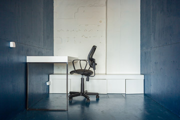 Loft style office with white brick walls and concrete columns. There is a meeting area with a large white table with black chairs