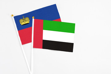 United Arab Emirates and Liechtenstein stick flags on white background. High quality fabric, miniature national flag. Peaceful global concept.White floor for copy space.