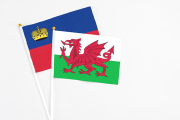 Wales and Liechtenstein stick flags on white background. High quality fabric, miniature national flag. Peaceful global concept.White floor for copy space.