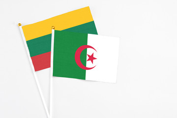 Algeria and Lithuania stick flags on white background. High quality fabric, miniature national flag. Peaceful global concept.White floor for copy space.