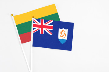 Fototapeta premium Anguilla and Lithuania stick flags on white background. High quality fabric, miniature national flag. Peaceful global concept.White floor for copy space.