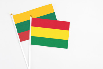Bolivia and Lithuania stick flags on white background. High quality fabric, miniature national flag. Peaceful global concept.White floor for copy space.
