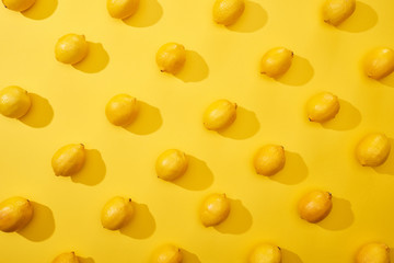 top view of ripe lemons on yellow background