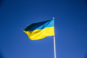 A Ukrainian flag in the blue sky