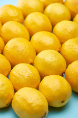 close up view of ripe yellow lemons on blue background