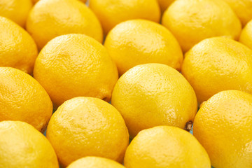 close up view of ripe yellow lemons on blue background
