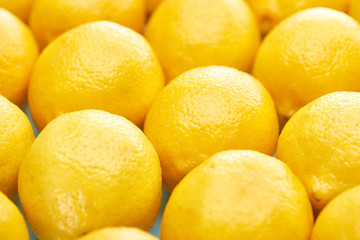 close up view of ripe yellow lemons on blue background