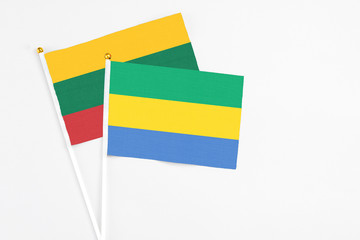 Gabon and Lithuania stick flags on white background. High quality fabric, miniature national flag. Peaceful global concept.White floor for copy space.