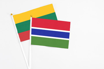 Gambia and Lithuania stick flags on white background. High quality fabric, miniature national flag. Peaceful global concept.White floor for copy space.