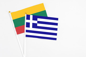 Greece and Lithuania stick flags on white background. High quality fabric, miniature national flag. Peaceful global concept.White floor for copy space.