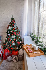 Beautiful holiday decorated room with Christmas tree with presents under it