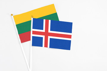 Obraz premium Iceland and Lithuania stick flags on white background. High quality fabric, miniature national flag. Peaceful global concept.White floor for copy space.