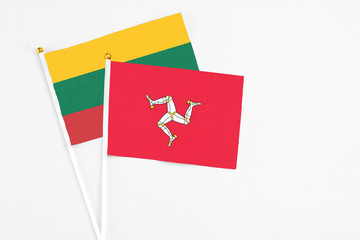 Isle Of Man and Lithuania stick flags on white background. High quality fabric, miniature national flag. Peaceful global concept.White floor for copy space.