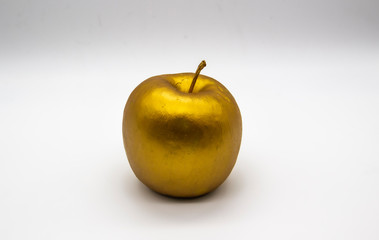 A golden apple on a white background