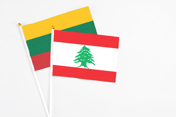 Lebanon and Lithuania stick flags on white background. High quality fabric, miniature national flag. Peaceful global concept.White floor for copy space.