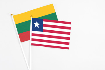 Liberia and Lithuania stick flags on white background. High quality fabric, miniature national flag. Peaceful global concept.White floor for copy space.
