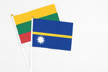 Nauru and Lithuania stick flags on white background. High quality fabric, miniature national flag. Peaceful global concept.White floor for copy space.
